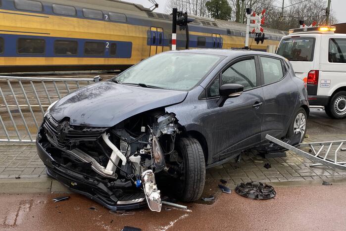 Automobilist rijdt door hekwerk bij spoorwegovergang NS-station