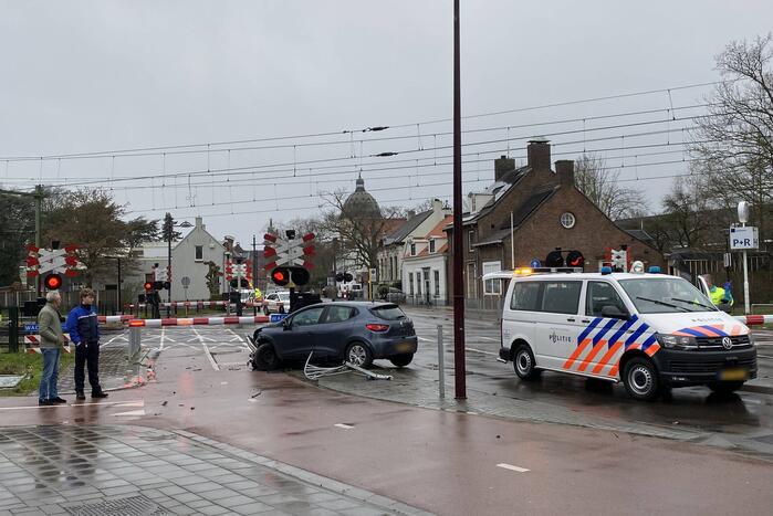 Automobilist rijdt door hekwerk bij spoorwegovergang NS-station