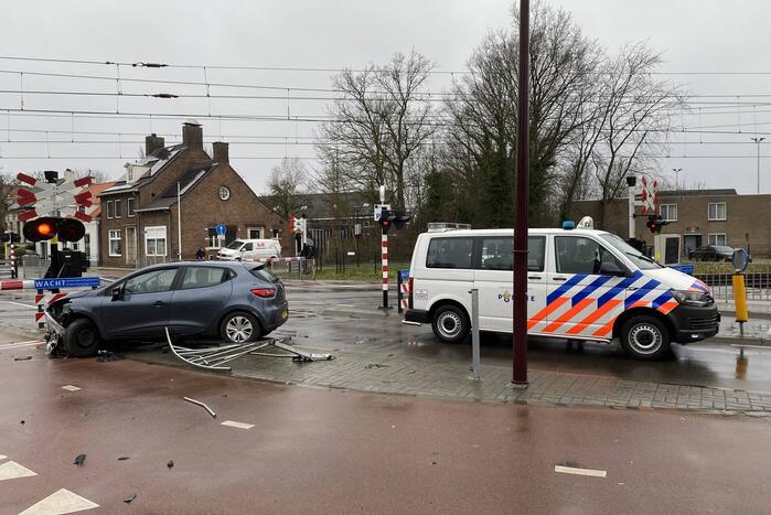 Automobilist rijdt door hekwerk bij spoorwegovergang NS-station