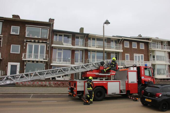 Brandweer verwijderd dakplaten en zet dakgoot vast