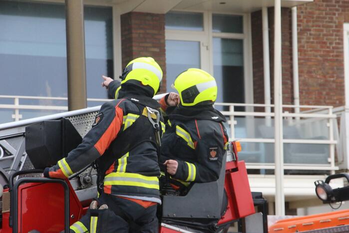 Brandweer verwijderd dakplaten en zet dakgoot vast