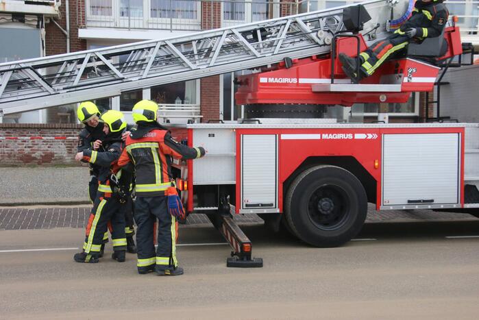Brandweer verwijderd dakplaten en zet dakgoot vast
