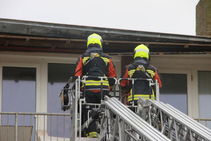 Brandweer verwijderd dakplaten en zet dakgoot vast