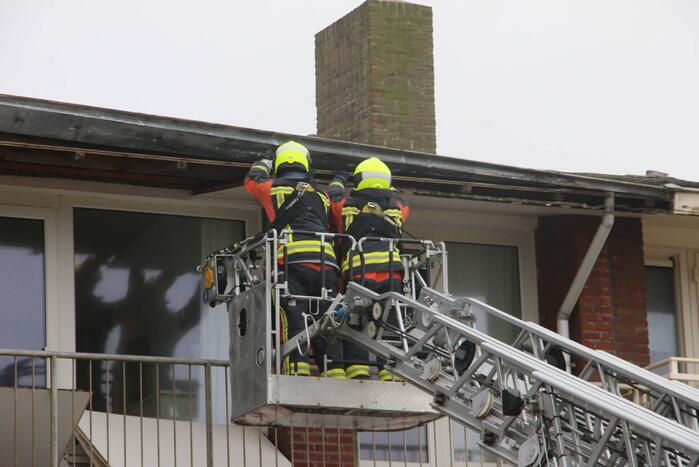 Brandweer verwijderd dakplaten en zet dakgoot vast