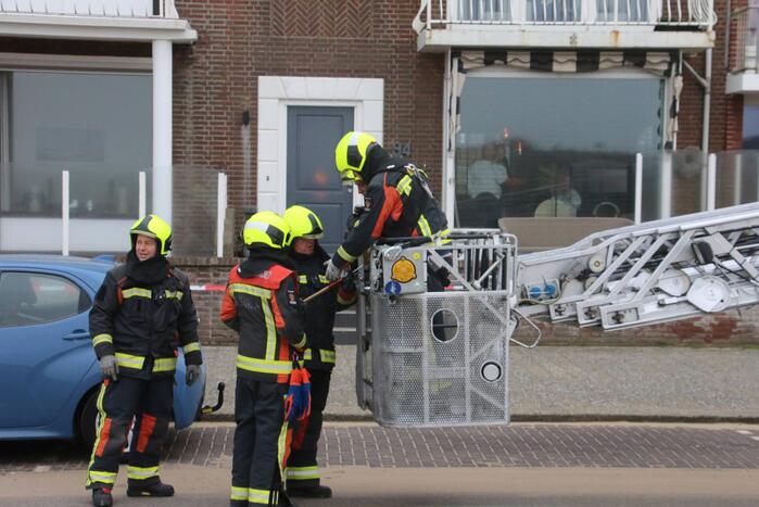 Brandweer verwijderd dakplaten en zet dakgoot vast