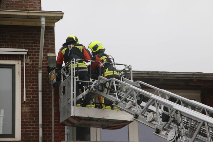 Brandweer verwijderd dakplaten en zet dakgoot vast