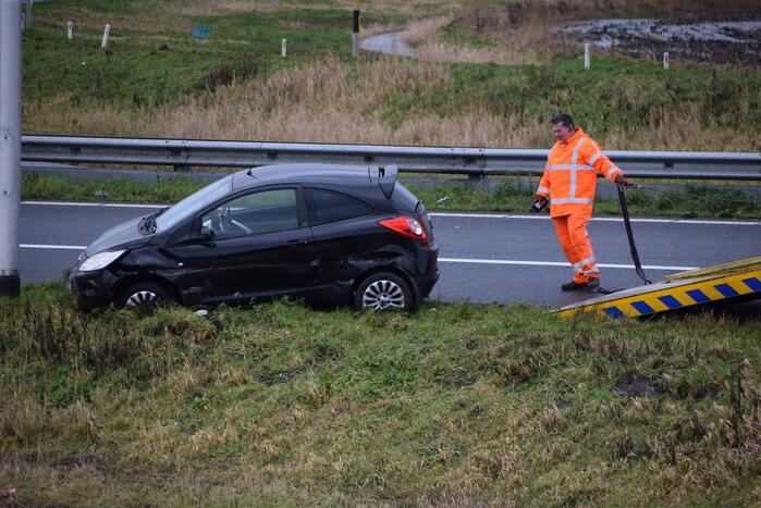 Auto raakt in slip op afrit