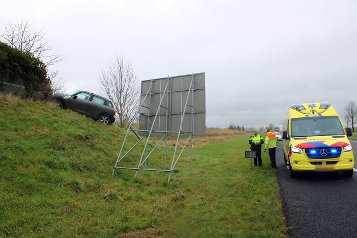 Automobilist raakt van de weg belandt boven op geluidswal