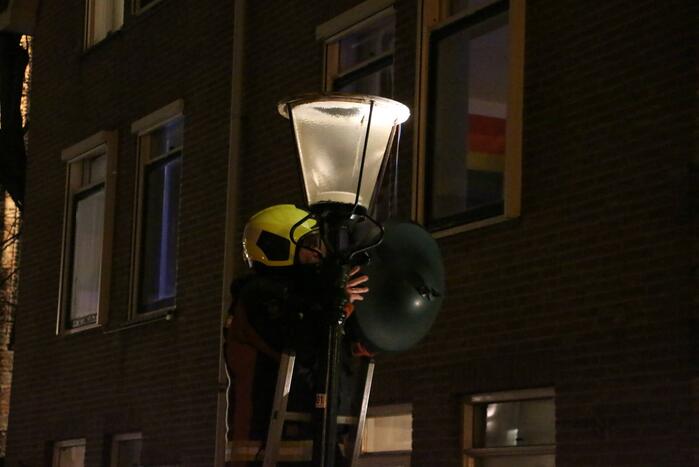 Brandweer haalt losse kap van lantaarnpaal
