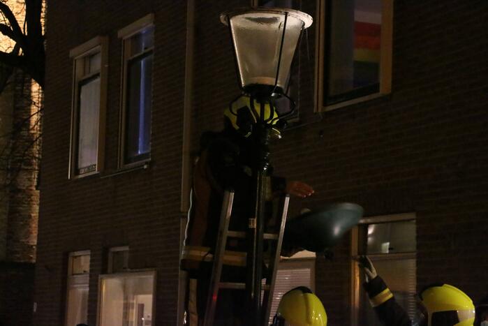 Brandweer haalt losse kap van lantaarnpaal
