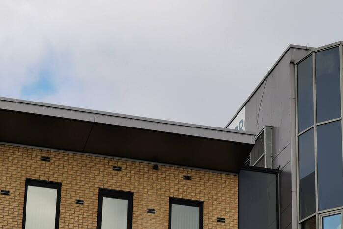 Bedrijfsbord waait los van kantoorpand