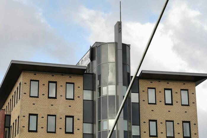 Bedrijfsbord waait los van kantoorpand