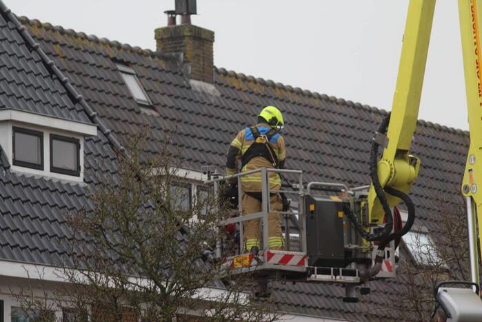Brandweer zet loszittende dakpannen vast