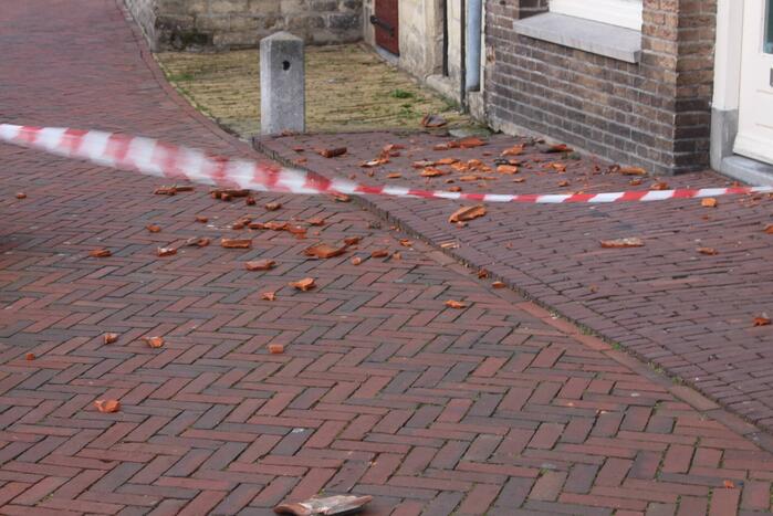 Dakpannen waaien van woning