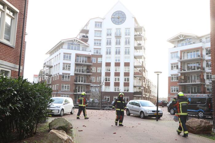 Dakpannen waaien van appartementencomplex