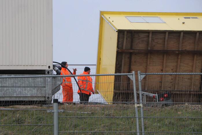 Bouwkeet waait om en belandt op wegdek