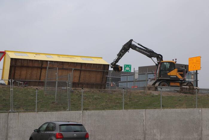 Bouwkeet waait om en belandt op wegdek