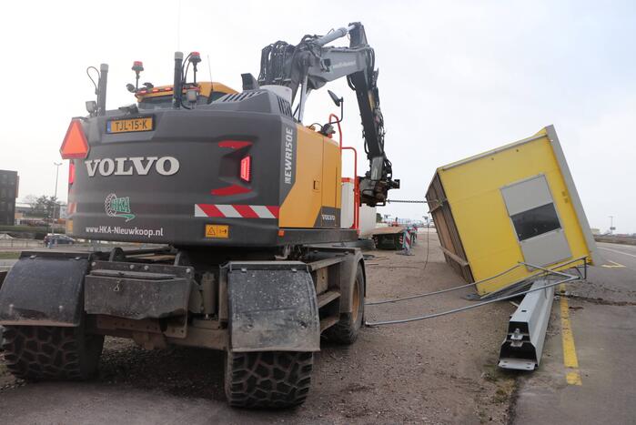 Bouwkeet waait om en belandt op wegdek