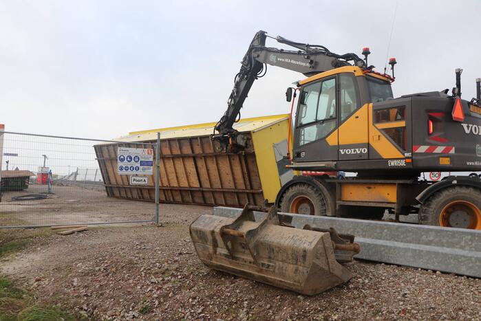 Bouwkeet waait om en belandt op wegdek