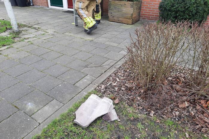 Brandweer plaatst dakpannen terug op woning