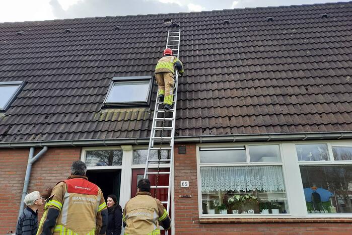 Brandweer plaatst dakpannen terug op woning