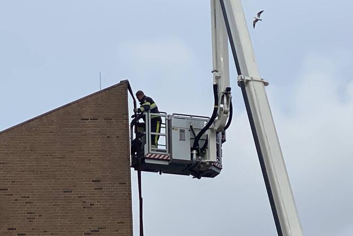 Brandweer verwijderd losgekomen dakbedekking