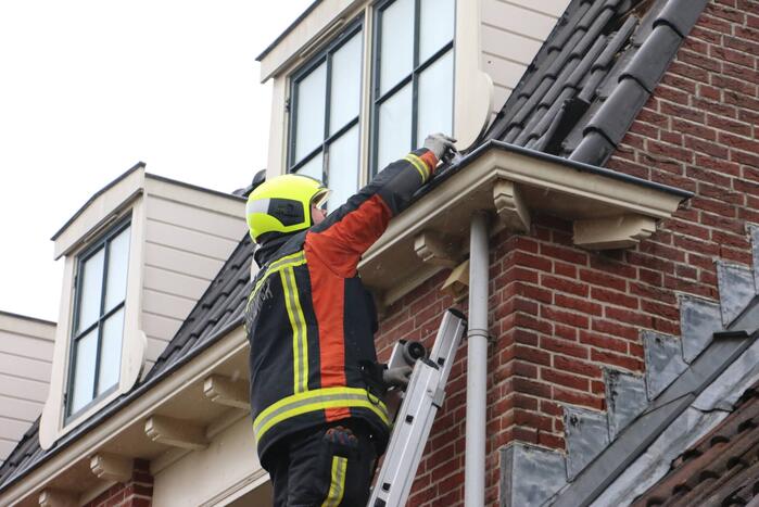 Brandweer verwijdert losse dakpannen van woning
