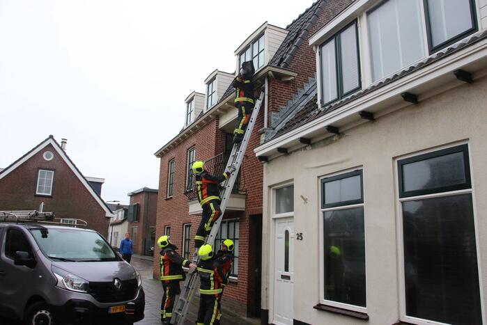 Brandweer verwijdert losse dakpannen van woning