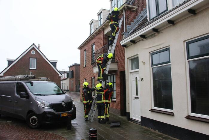 Brandweer verwijdert losse dakpannen van woning