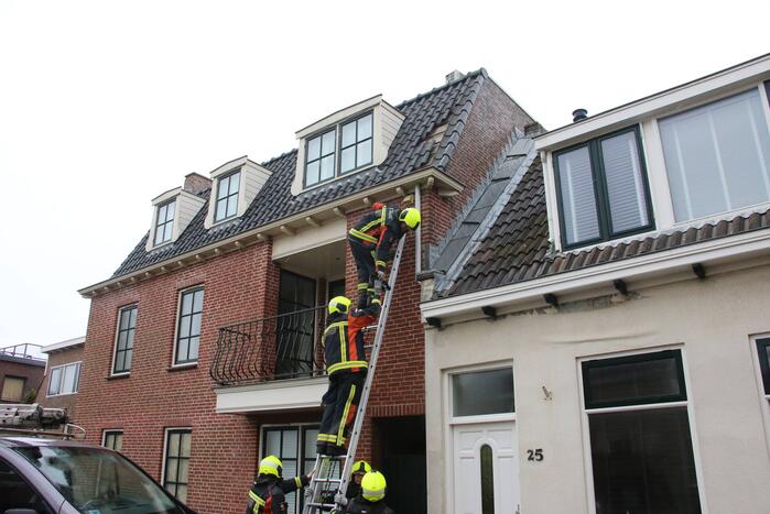 Brandweer verwijdert losse dakpannen van woning