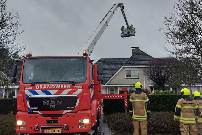 Brandweer verwijderd losse plaat op schoorsteen van woning