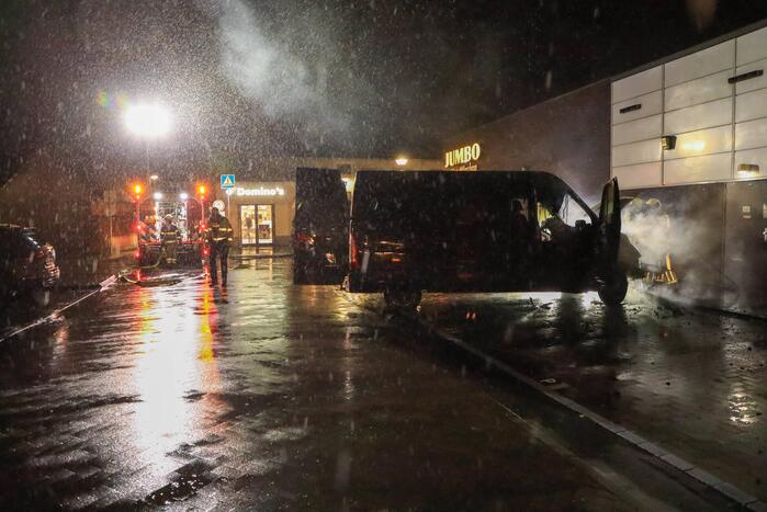 Bestelbus in brand tegen gevel Jumbo