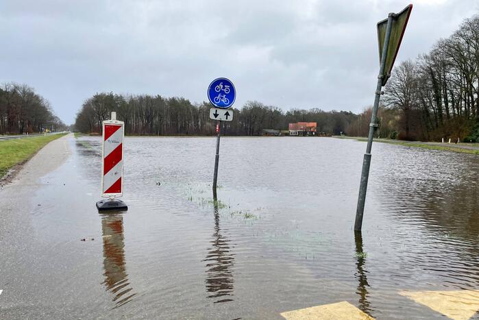 Wegdek en fietspad onder water door hevige regenval