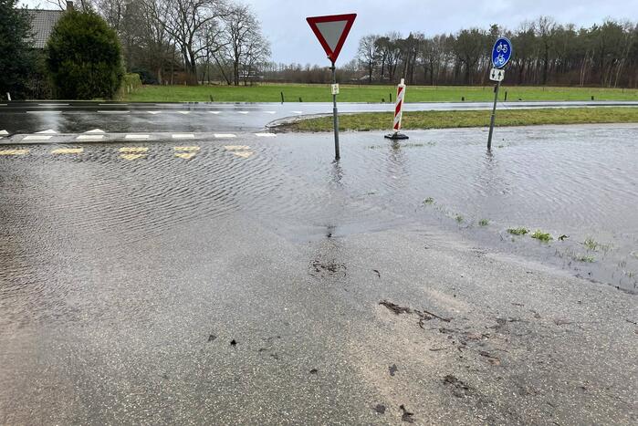Wegdek en fietspad onder water door hevige regenval