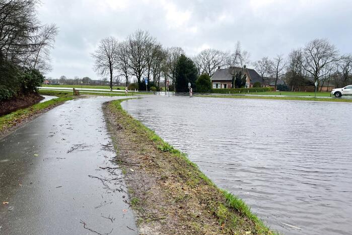 Wegdek en fietspad onder water door hevige regenval