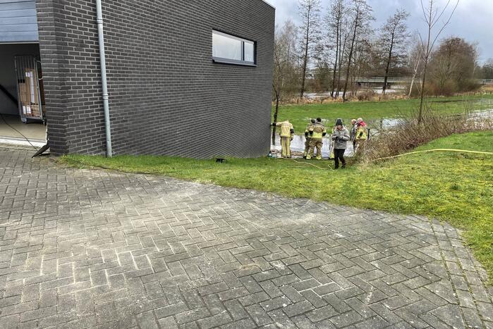 Overtollig water dreigt bedrijfspand binnen te stromen