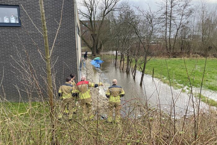 Overtollig water dreigt bedrijfspand binnen te stromen