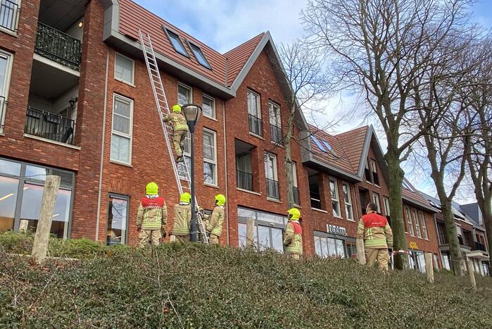 Voetpad afgesloten door losgeraakte dakpannen