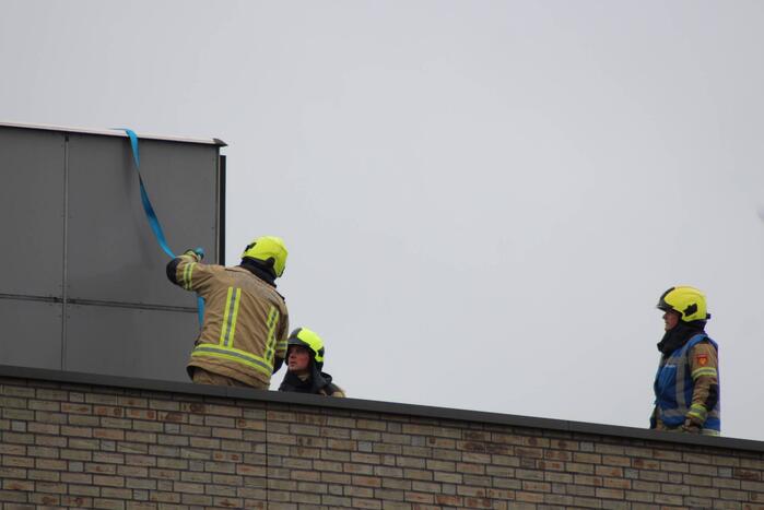 Platen ventilatiesysteem op dak van schoolgebouw waaien los