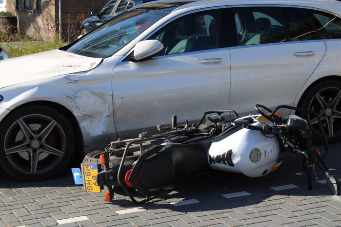 Bestuurder lesmotor knalt op geparkeerde auto