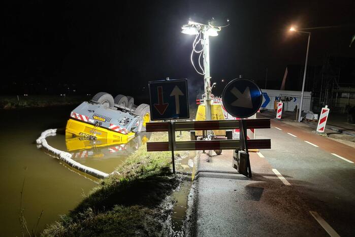 Kraan zakt weg en valt om in water