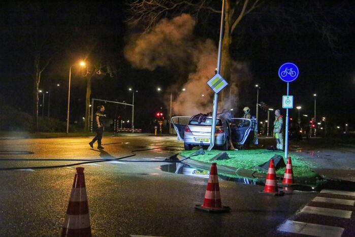 Auto vliegt in brand na botsing tegen boom