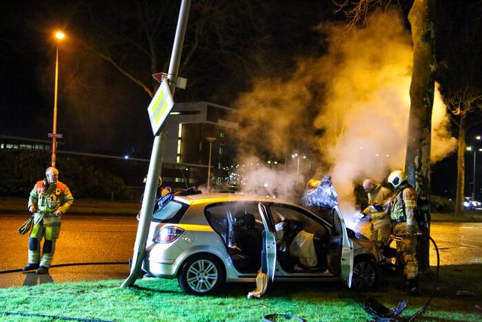 Auto vliegt in brand na botsing tegen boom