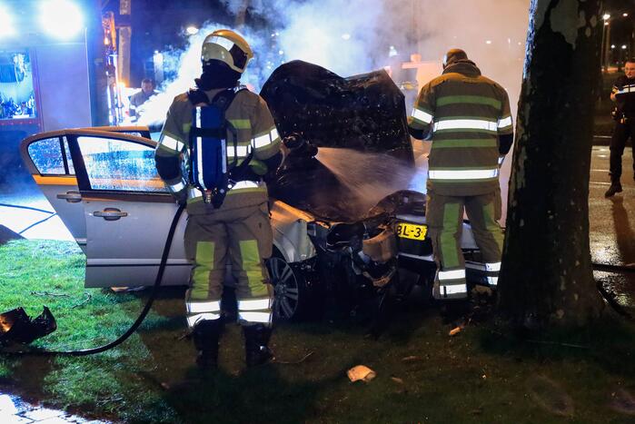 Auto vliegt in brand na botsing tegen boom