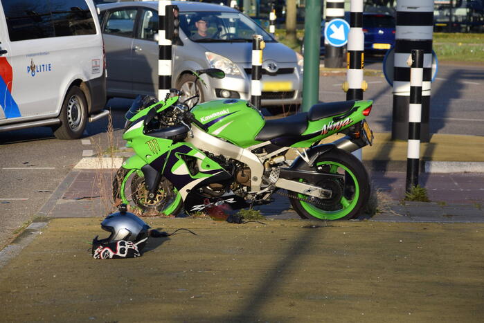 Motorrijder glijdt tegen lijkwagen