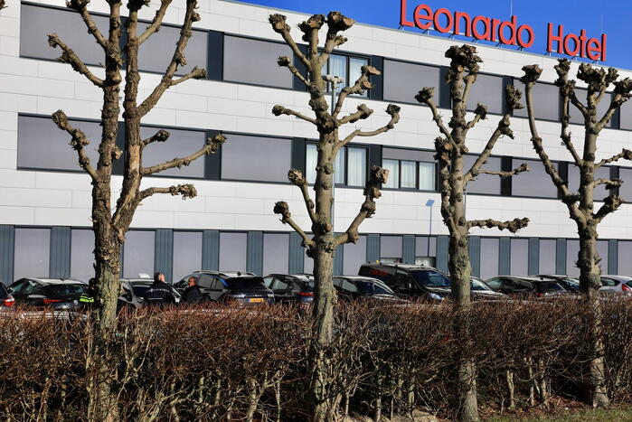 Wild-west-tafereel met automatisch wapen op parkeerplaats Leonardo Hotel