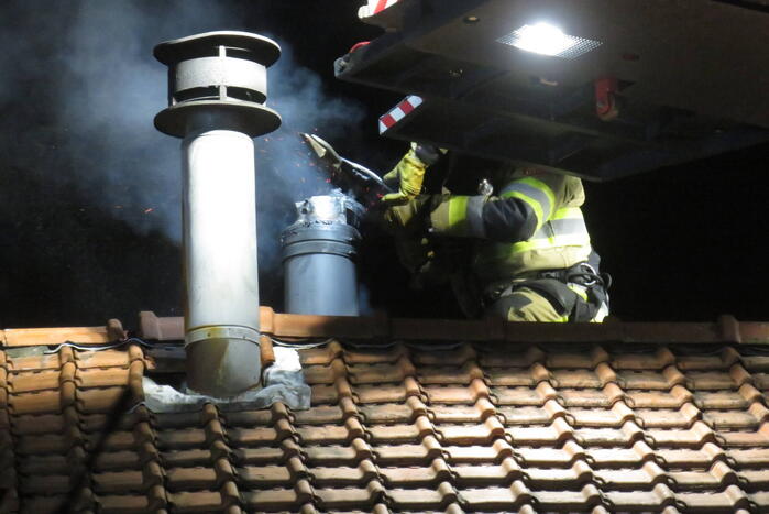 Vonken slaan uit schoorsteen van woning