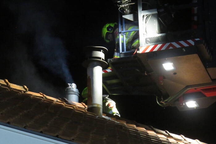 Vonken slaan uit schoorsteen van woning