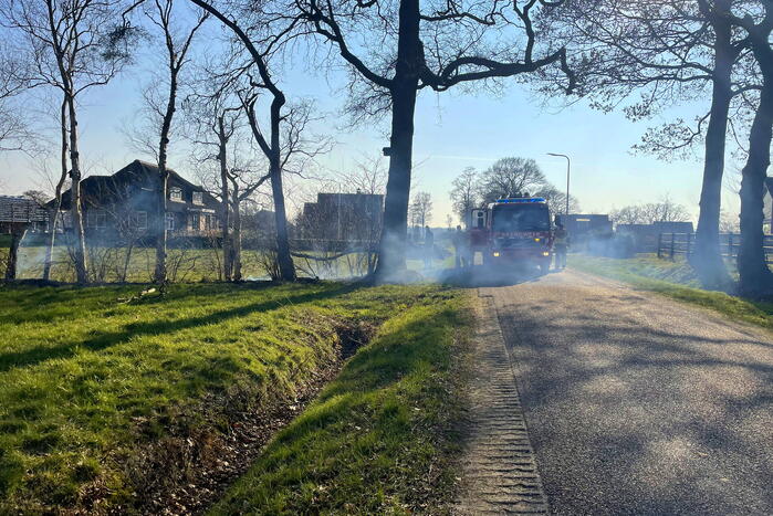 Brandweermannen blussen bermbrand
