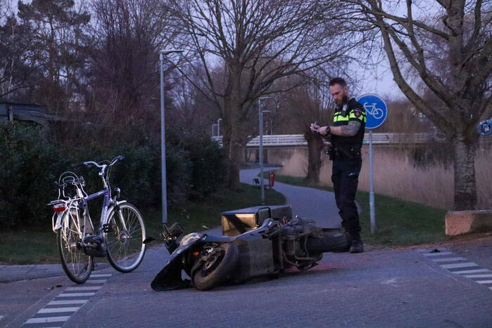 Fietser en bezorger op scooter in botsing